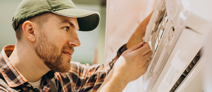 Certified technician cleaning and servicing a home air conditioner